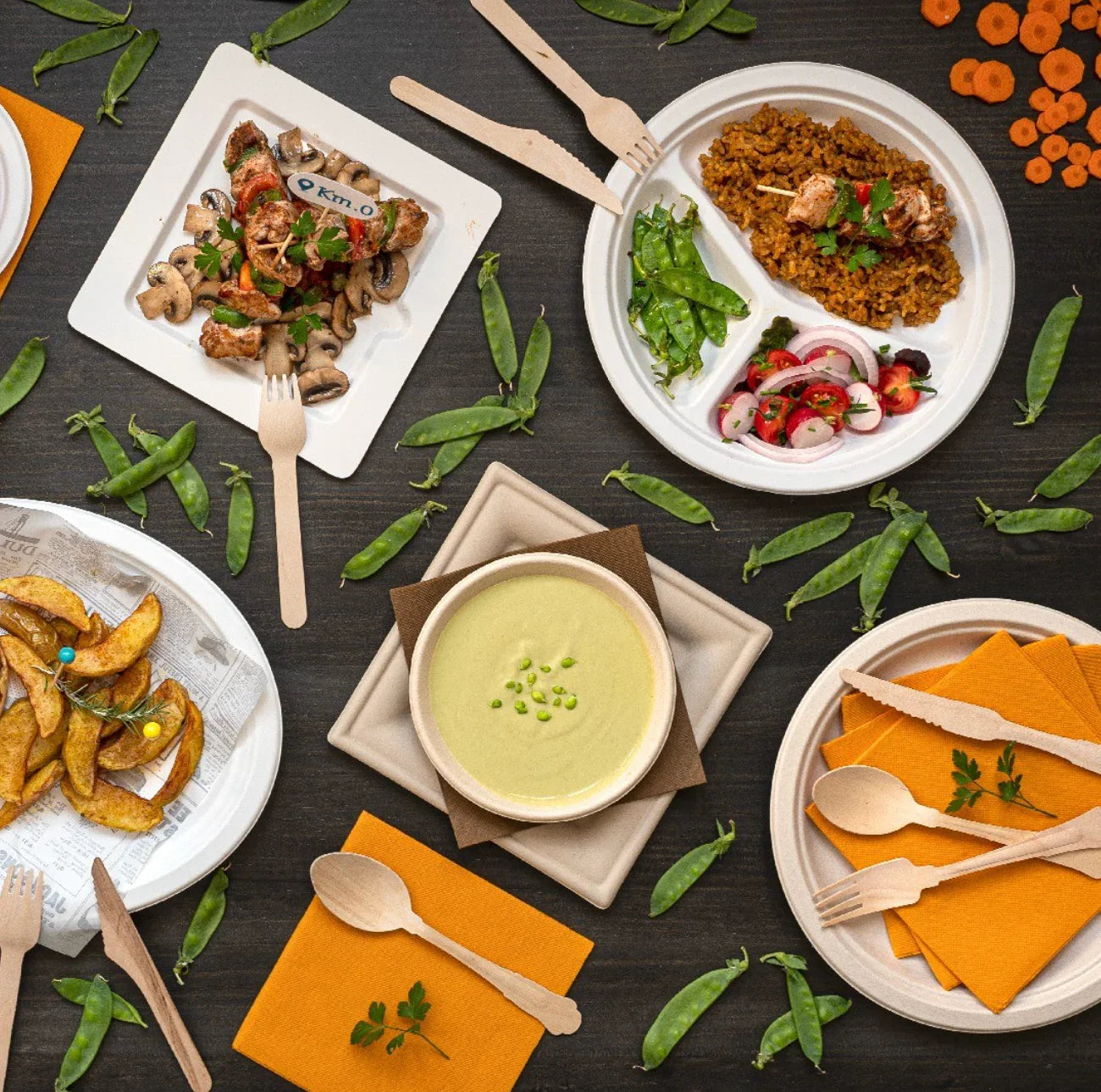 Conjunto de Talheres de Madeira Descartáveis ao lado de pratos com comida, incluindo sopa e saladas.