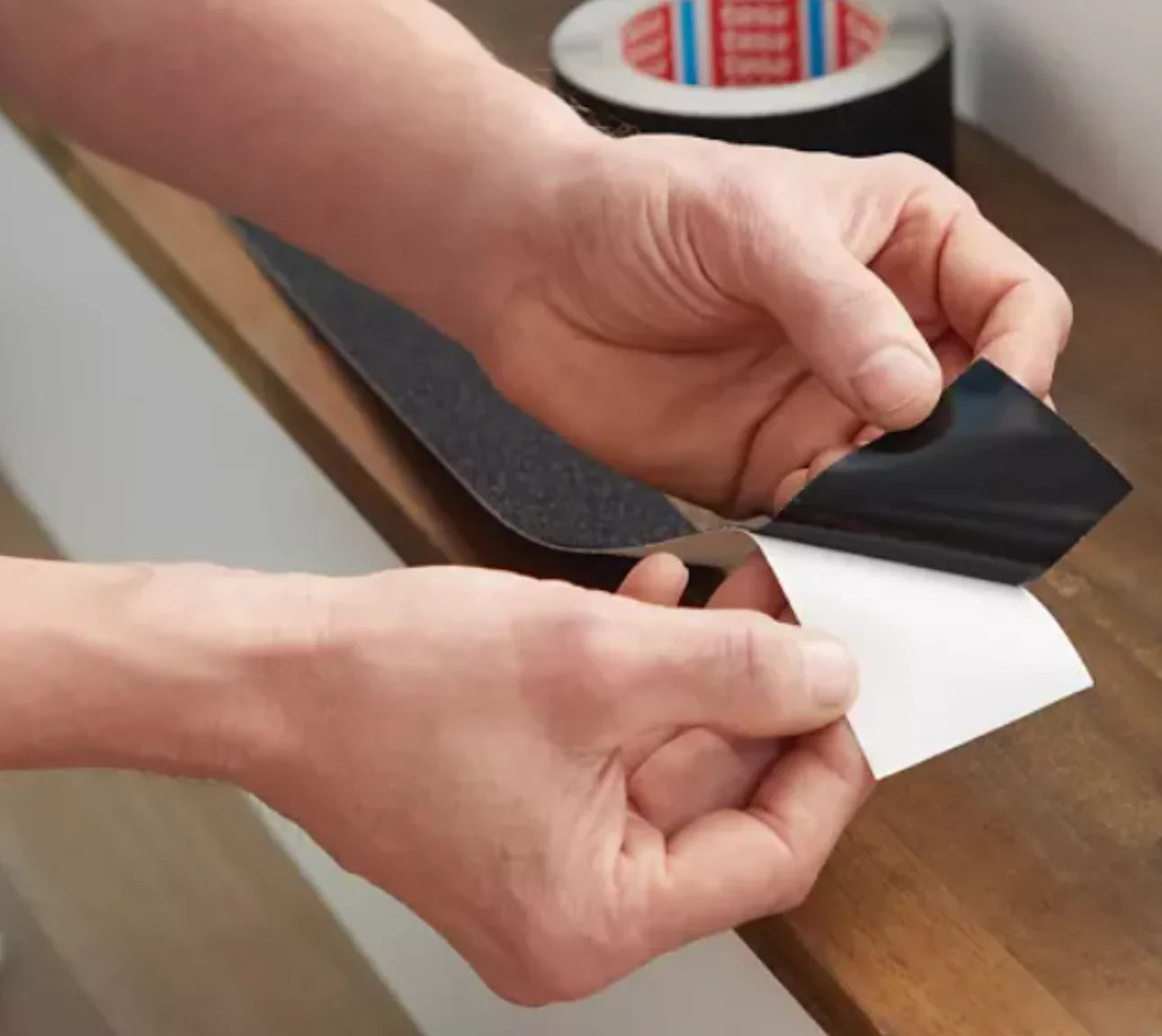 Fita Adesiva Anti-Derrapante sendo aplicada em uma superfície, demonstrando alta aderência e segurança.