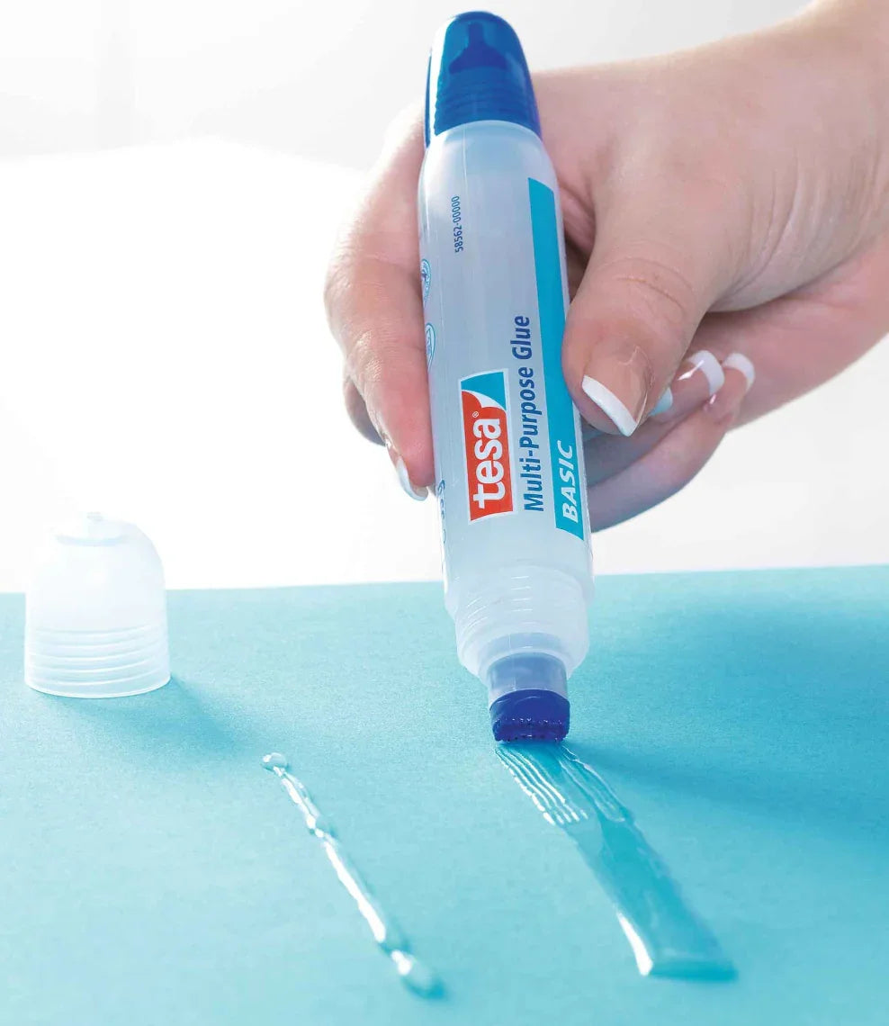 Cola Líquida Multiusos TESA a ser aplicada em papel, destacando seu uso prático e versatilidade.
