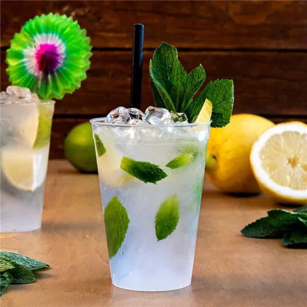 Copo Plástico PP Forte Reutilizável 500ml com bebida refrescante e folhas de hortelã.