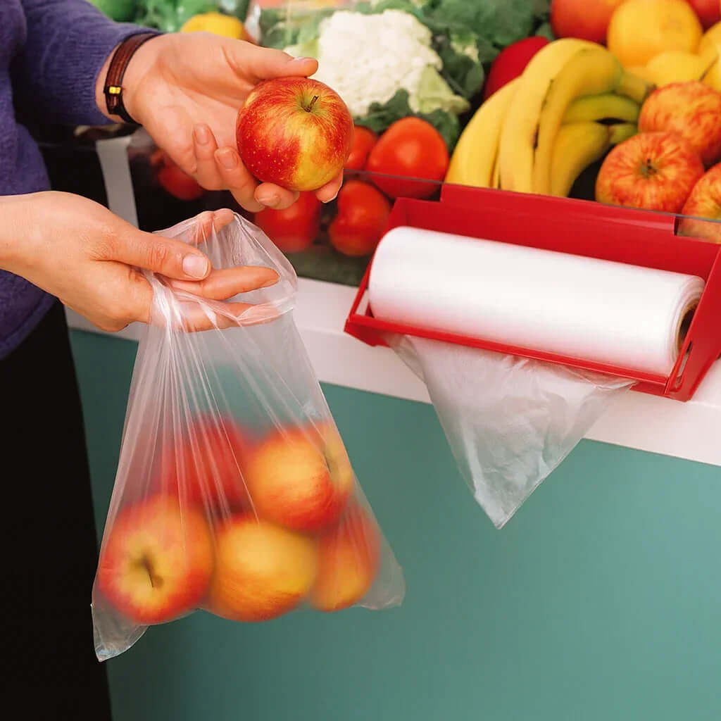 Saco Plástico Fino Transparente PEAD 30x40cm em Rolo utilizado para transporte de maçãs em supermercado.