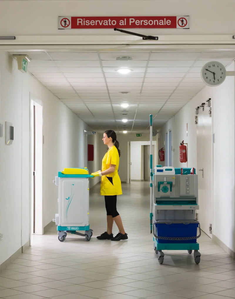 Carrinho Limpeza Hospitalar TTS em corredor hospitalar com funcionária usando equipamento de limpeza.