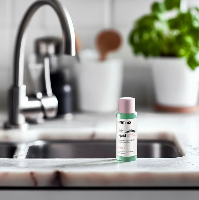 Detergente da Loiça Manual Concentrado Mini Amenitie em frasco de 30ml na bancada de uma cozinha moderna.