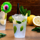 Copo Plástico PP Forte Reutilizável 180ml com bebida refrescante e decoração de hortelã.