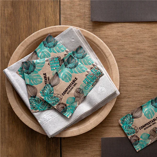 Toalhita Refrescante Compostável Perfumada em mesa com toalha e pratos, ideal para higiene rápida das mãos em prestaurantes, cervejarias e marisqueiras