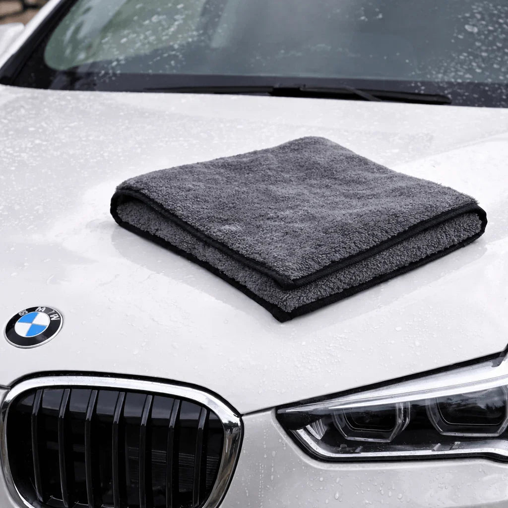 Pano Toalha Microfibra de Volume Extra sobre capô de carro, ideal para limpeza automotiva e alta absorção.