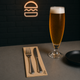 Guardanapos de Mesa Eco Nature Dobrados 1-6 PPP 30x40cm ao lado de um copo de cerveja e talheres sobre uma mesa.