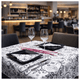Toalhas de Mesa Decoradas em Bloco em ambiente de restaurante, mesa com pratos e copos elegantes.
