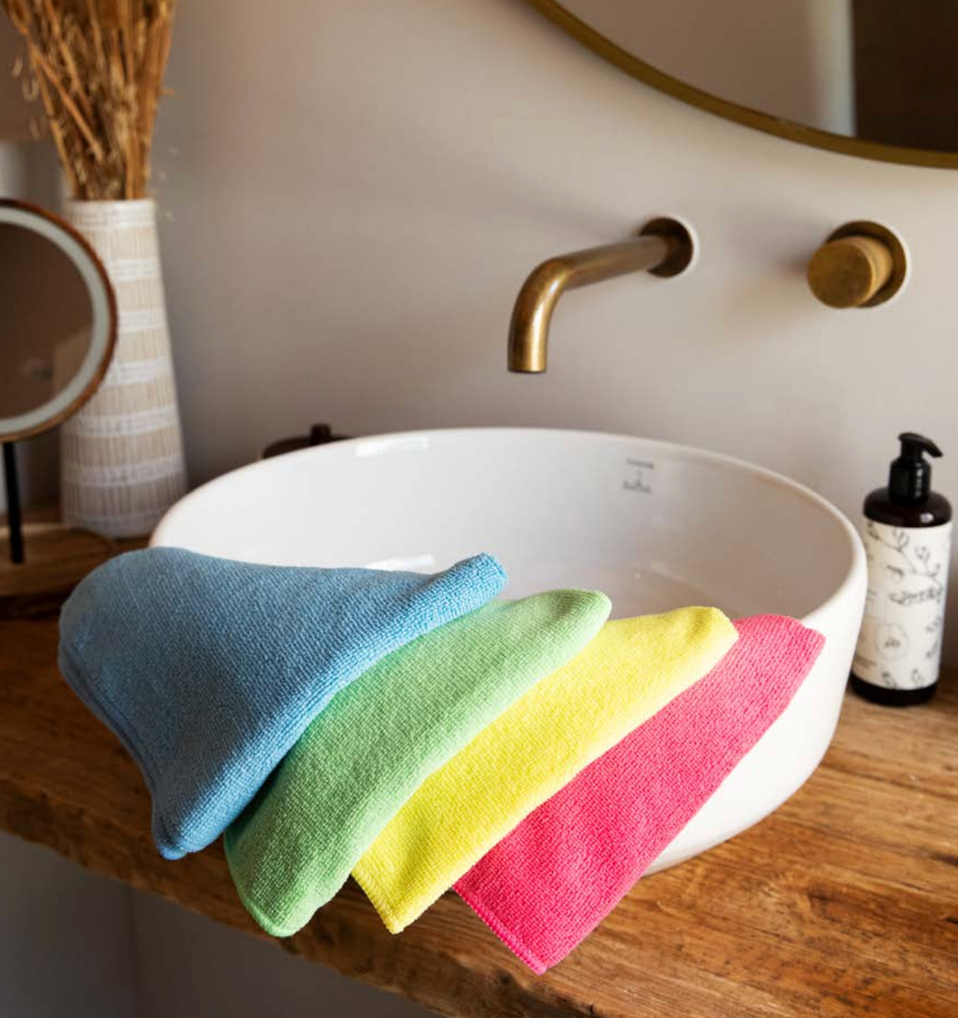 Pano Microfibra Multiusos T-28 em várias cores sobre uma bancada ao lado de uma pia moderna.